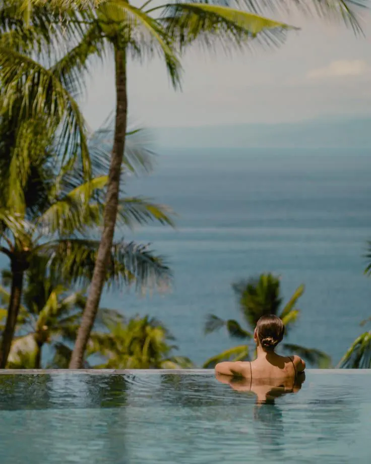 A guest in an infinity pool looking out to sea